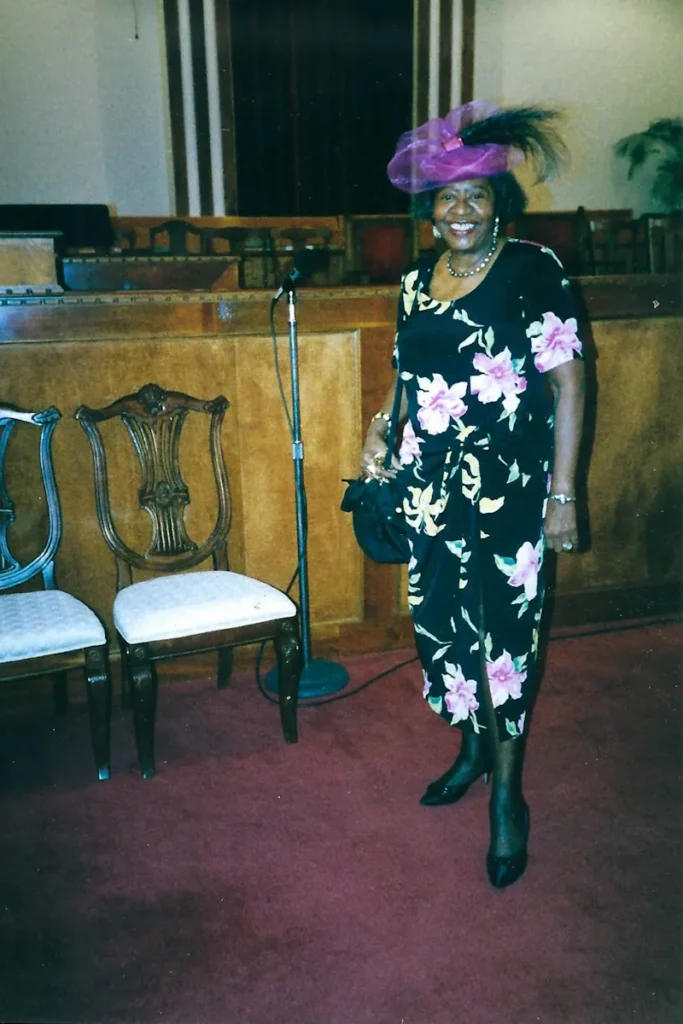 Dolores at church in a purple hat